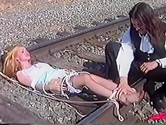 Ticklish damsel tickled on railroad tracks...
